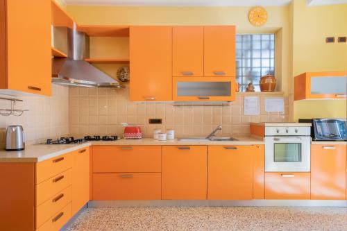 una cocina naranja con electrodomésticos blancos y armarios naranjas en Petroni 38 by Studio Vita, en Bolonia