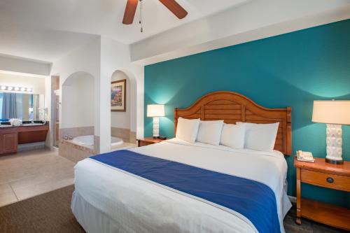 1 dormitorio con 1 cama grande y pared azul en Lake Buena Vista Resort Village and Spa, a staySky Hotel & Resort Near Disney en Orlando