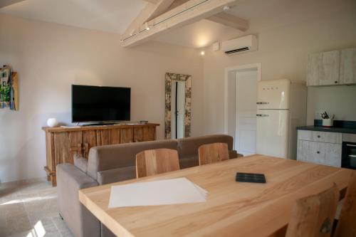 un salon avec un canapé, une table et une télévision dans l'établissement Les Pins de l'Escalet, à Ramatuelle
