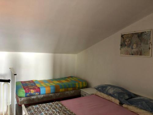 Habitación pequeña con 2 camas y una pintura en la pared. en Costaverde Home, en Mandatoriccio Marina
