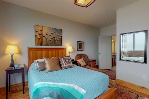 a bedroom with a bed and a chair and a window at Seasons at Sandpoint in Sandpoint