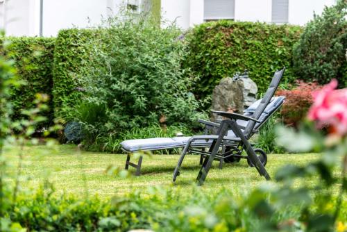 two chairs sitting in the grass in a yard at Bavaria Hotel in Ingolstadt