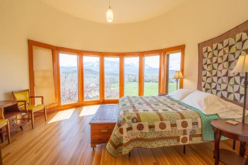 a bedroom with a bed and some windows at Wisehart Springs Inn in Paonia
