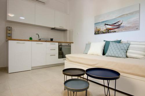 eine Küche und ein Wohnzimmer mit 2 Stühlen und einem Sofa in der Unterkunft Giorgos villa in Palekastro