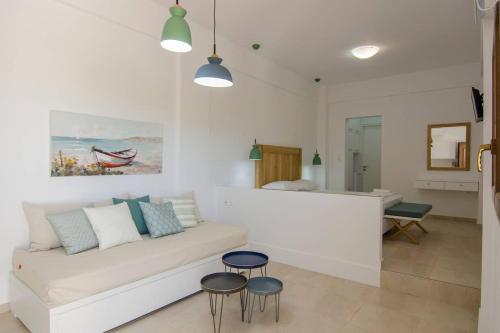 uma sala de estar com um sofá branco e dois bancos em Giorgos villa em Palekastron