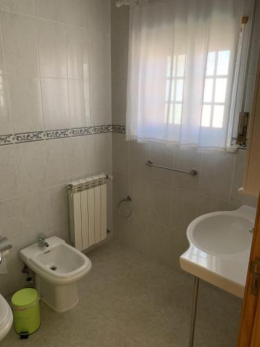 a bathroom with a white toilet and a sink at Santa Barbara Healthcare & Villas in Mariquiteira