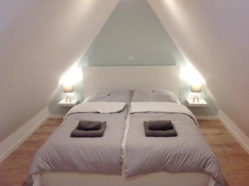 a bedroom with a large bed with two pillows on it at Traumhaus am Weserstrand in Elsfleth