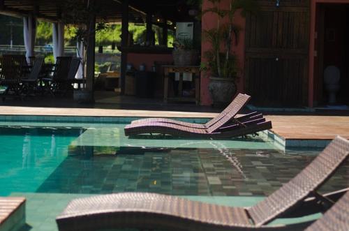 two lounge chairs sitting next to a swimming pool at Pousada e Mergulho Jamanta in Angra dos Reis