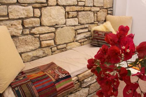 a bed in a room with a stone wall at Landros in Kamilari