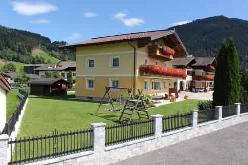 a yellow house with a playground in a yard at Haus Anni in Radstadt