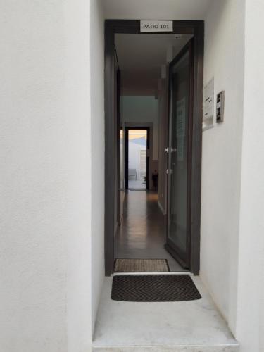 a hallway with an open door with a hallway rug at Patio 101 "Exclusive" in San Vito lo Capo