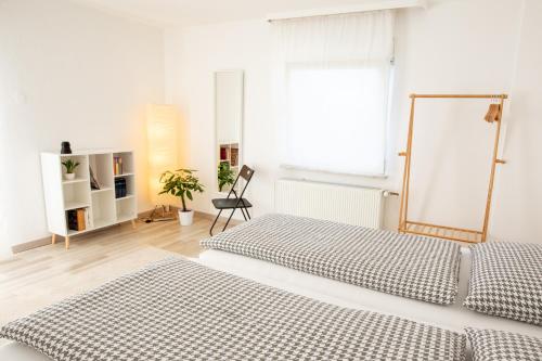 a white bedroom with two beds and a window at Ferienhaus Ko-Living in Koblenz