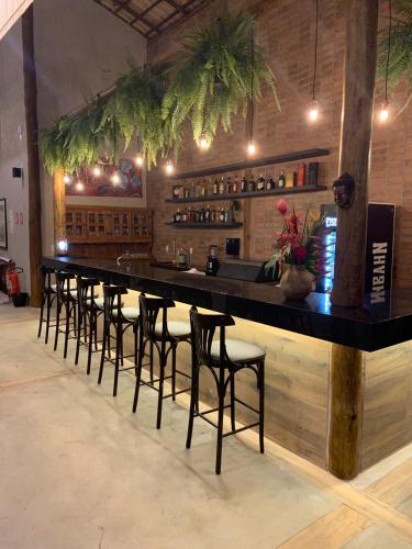 a bar with a row of stools in a room at Pousada Aldeia da Serra in Palmas