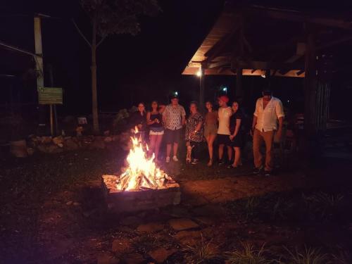 a group of people standing around a fire pit at night at Honduyate in Las Marías