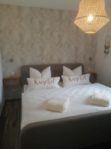 a bedroom with a white bed with white pillows at Haus Ostwind in Zinnowitz