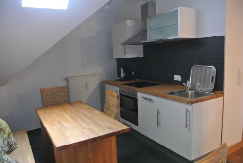a small kitchen with a sink and a table at Gästehaus Sektstuuf St. Laurentius in Leiwen