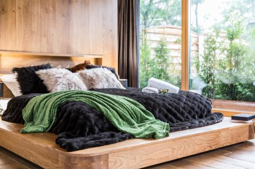 a bed with a green and black blanket on it at Nowy komfortowy Apartament & Spa Grizzly de lux in Zakopane