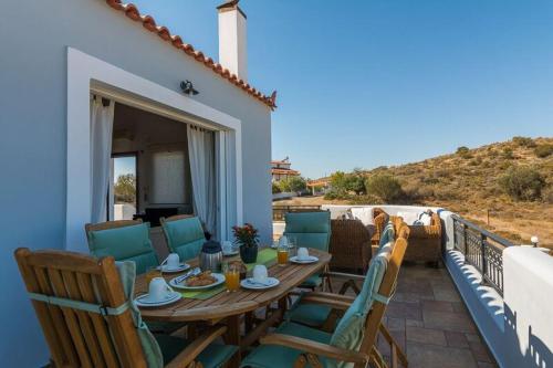 a wooden table and chairs on a balcony at HOUSE NEXT TO THE SEA in Ermioni