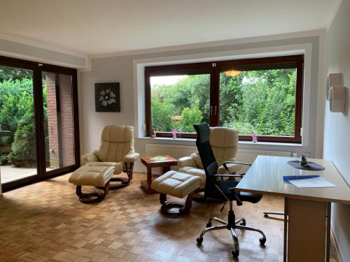 an office with chairs and a desk and two windows at Elbe Ferienwohnung Glückstadt in Glückstadt