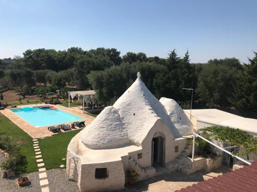 an external view of a house and a swimming pool at Trullo Grazioso Luxury in Ceglie Messapica