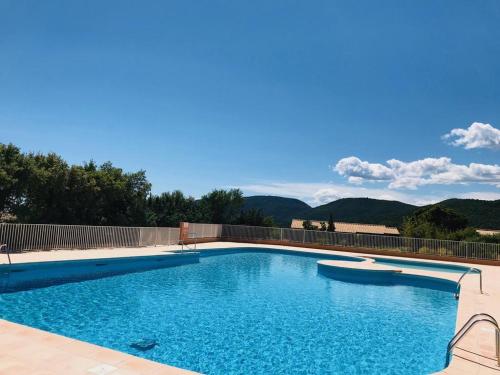 une piscine avec de l'eau bleue et des montagnes en arrière-plan dans l'établissement Les Emeraudes, à La Croix-Valmer