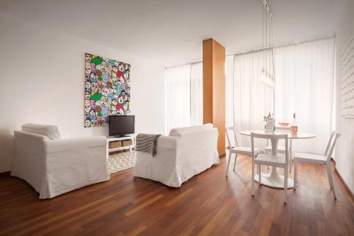 ein Wohnzimmer mit 2 weißen Stühlen und einem Tisch in der Unterkunft LA CHIARETTO SUITE in Bardolino