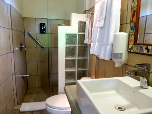 a bathroom with a toilet and a sink and a shower at Pura Vida Hotel in Alajuela City