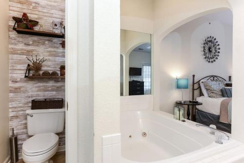 a bathroom with a tub and a toilet and a bed at Hideaway at Holiday Hills in Branson