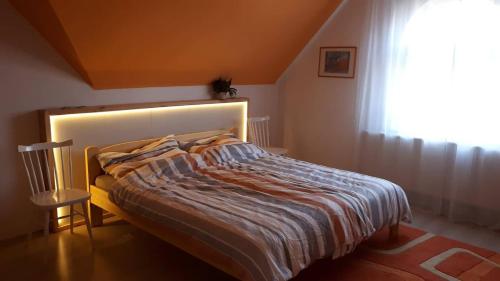 1 dormitorio con 1 cama grande y ventana en Barátságos ház emelete en Debrecen