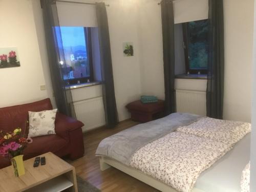 1 dormitorio con 1 cama, 1 sofá y 2 ventanas en Ferienwohnung Poganz, en Sankt Veit an der Glan