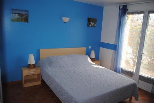 een blauwe slaapkamer met een bed en een raam bij EL ROCIO 1 GITES EQUESTRE in Saintes-Maries-de-la-Mer