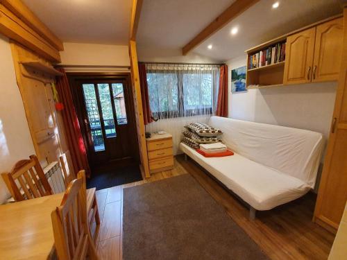 a small bedroom with a bed and a table at Apartamenty Cicha Dolina in Jurgów
