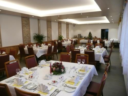 een eetkamer met tafels en stoelen met witte tafelkleden bij Hotel Adelboden in Wikon