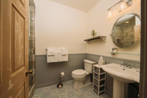 a bathroom with a toilet and a sink and a mirror at The Kendall in Boerne