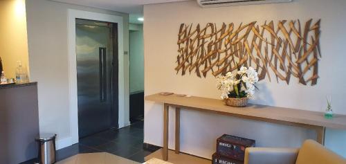 a lobby with a table and flowers on a wall at Ilhabela Park Hotel in Brasilia