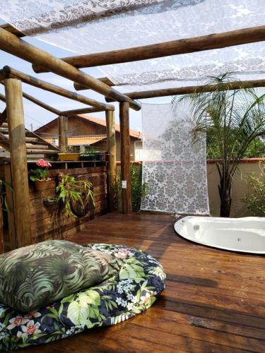 a large pillow on a wooden deck with a bath tub at Recanto Rustico Itapoá in Itapoa