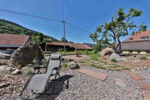 a bench sitting in the middle of a yard at Locations des 3 sommets avec Sauna et Spa en Alsace in Sondernach