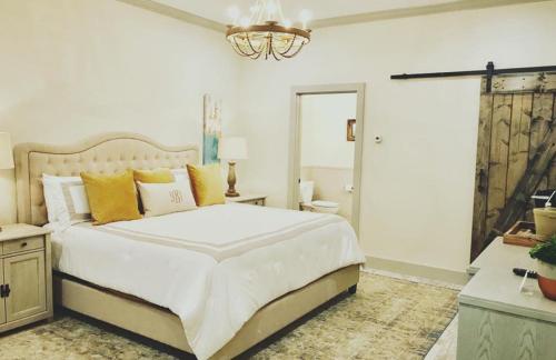 a bedroom with a large white bed and a chandelier at The Kendall in Boerne