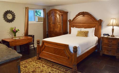 Silverton Inn & Suites في سيلفيرتون: غرفة نوم مع سرير خشبي كبير ومكتب