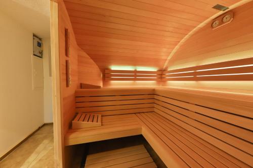 a wooden sauna with a bench in the middle at Locations des 3 sommets avec Sauna et Spa en Alsace in Sondernach