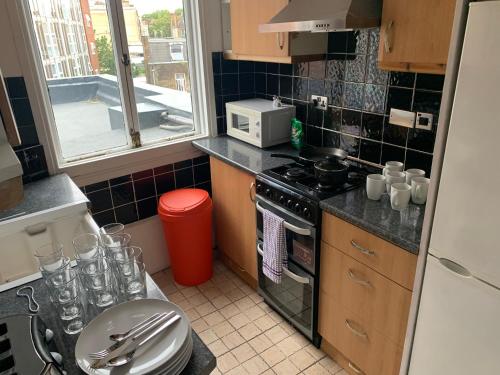a small kitchen with a stove and a microwave at Chelsea Apartments in London