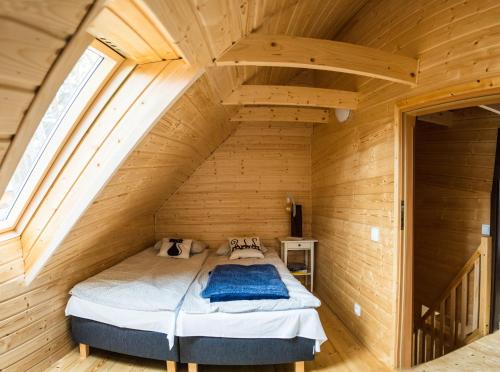 a bedroom with a bed in a wooden cabin at Domki ALEX przy plaży in Dziwnówek