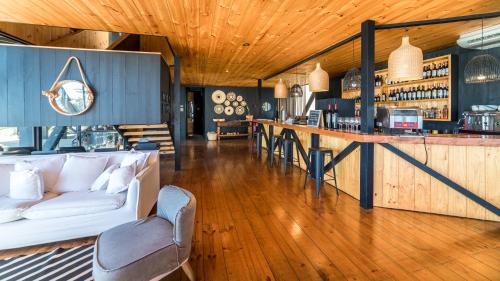 a living room with a couch and a bar at Hotel Puerto Viejo Llico in Llico