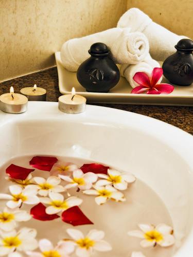 a bathroom with candles and flowers in a sink at Aanari Hotel & Spa- Mauritius in Flic-en-Flac