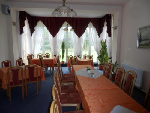 a dining room table with chairs and umbrellas at Penzion u Zámku in Habartov