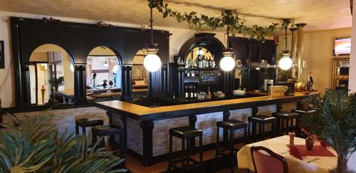 a bar in a restaurant with chairs and tables at La Fontana in Langelsheim