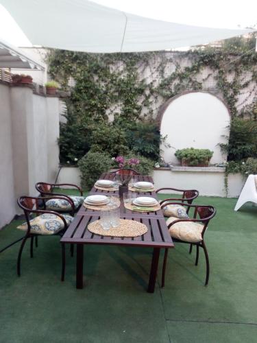 a wooden table and chairs with plates on it at B&B Palazzo Bianchi in Parma