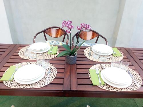a table with white plates and chairs and flowers at B&B Palazzo Bianchi in Parma