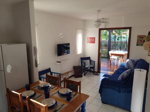 a living room with a blue couch and a table at Apartamento Solar do Forte - Praia do Forte in Praia do Forte