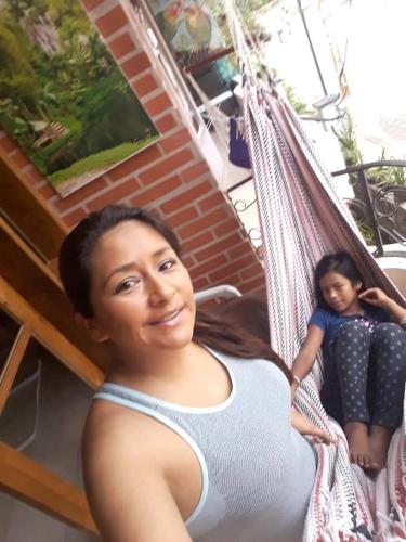 a woman sitting on a hammock with a little girl at Casa Cultural Mindo in Mindo